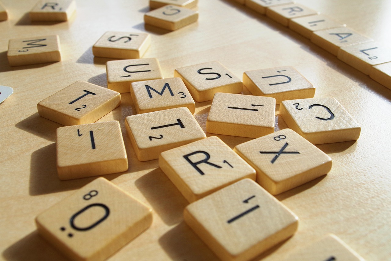 Scrabblen puisia pelinappuloita, joissa on kirjaimia ja numeroita.