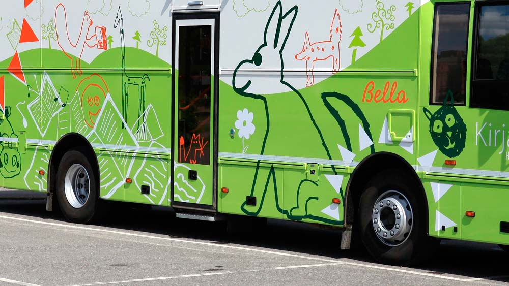Kirjastoautot. Hämeenlinnan vihreävalkoinen kirjastoauto, jonka kyljessä on eläinpiirroksia.